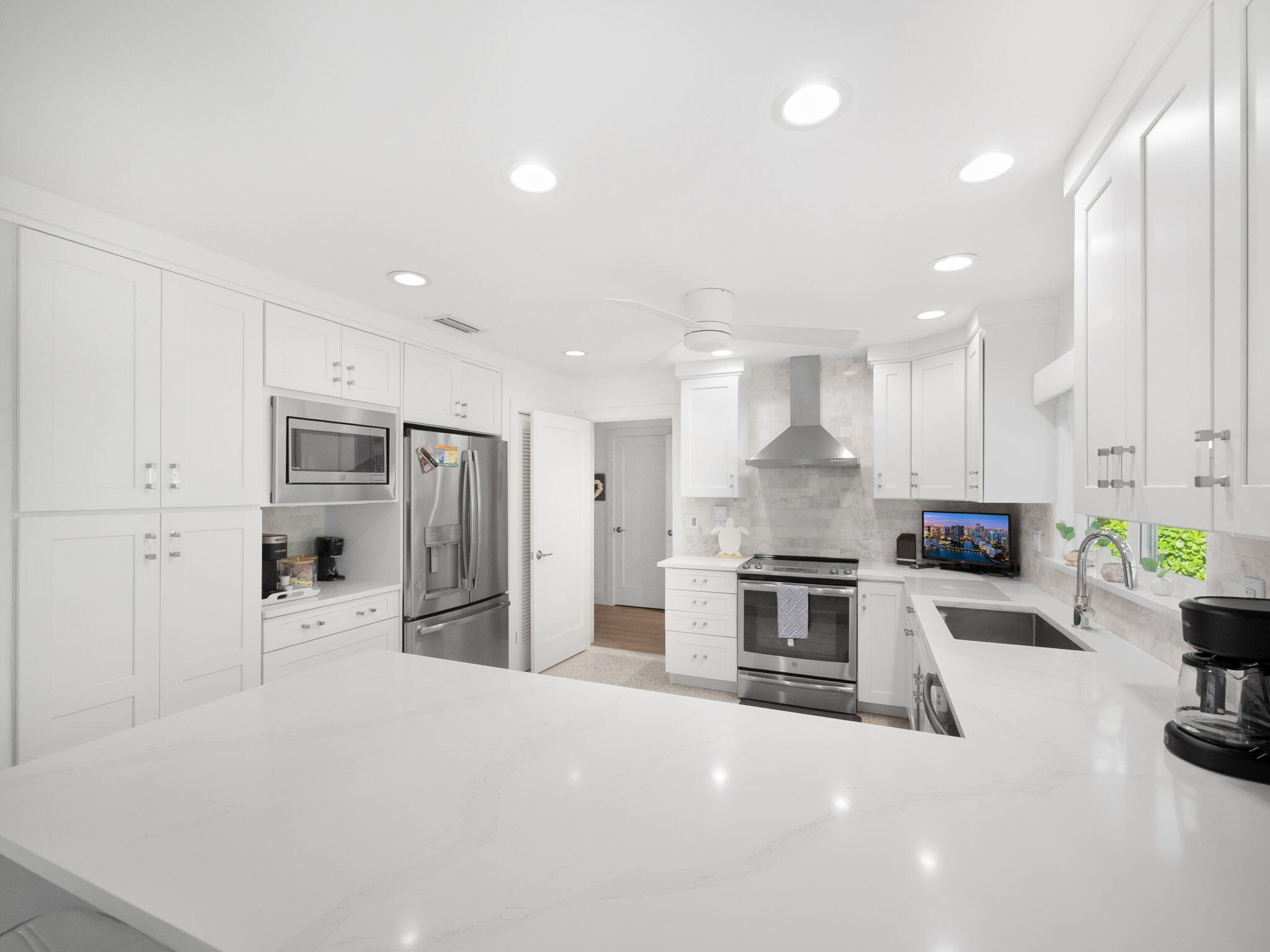 471 Mars Way Juno Beach, FL 33408 - Photo 7 of 29 a large kitchen with stainless steel appliances kitchen island granite countertop a large stove a refrigerator a oven and a sink with large countertops