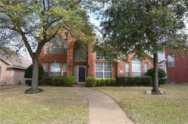 a front view of a house with a yard and trees