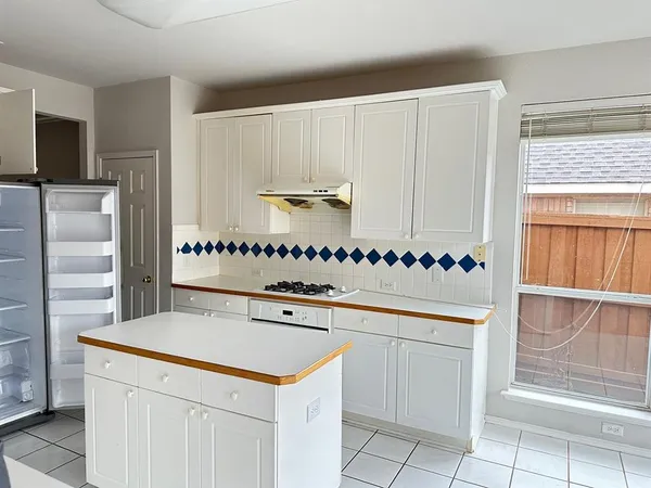 a kitchen with granite countertop white cabinets and a stainless steel appliances