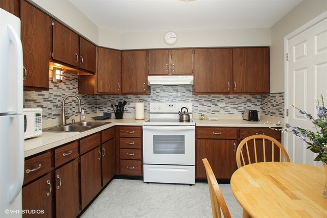 611 West Central Road, Unit C5 Mount Prospect, IL 60056 - Photo 5 of 10 a kitchen with stainless steel appliances granite countertop a sink stove and cabinets