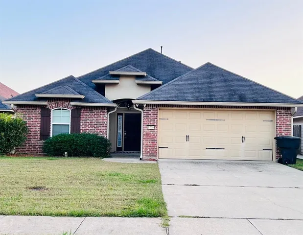 a front view of house with yard and garage