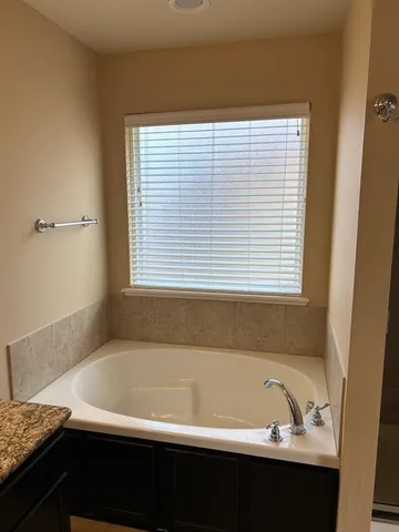 a bathroom with a bathtub and a window