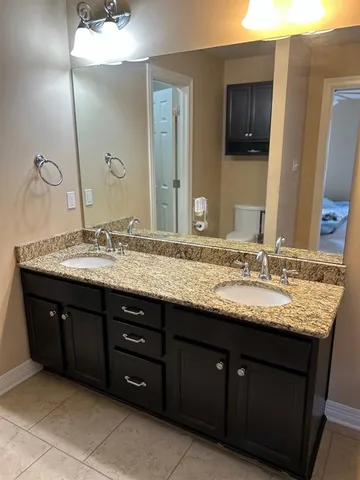 a bathroom with a granite countertop double sink and a mirror