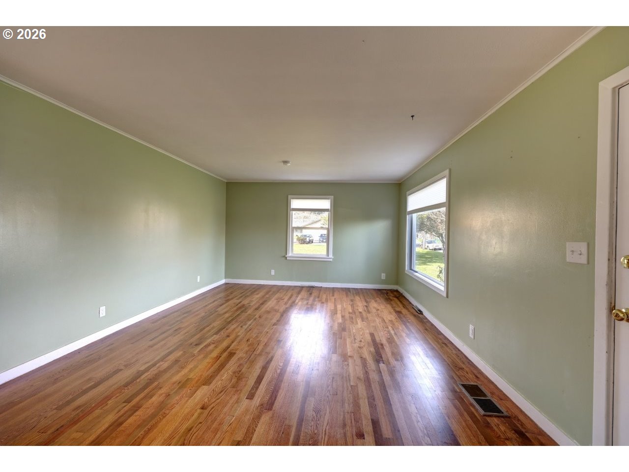 135 Southwest 2nd Street Warrenton, OR 97146 - Photo 22 of 46 a view of an empty room and window and wooden floor