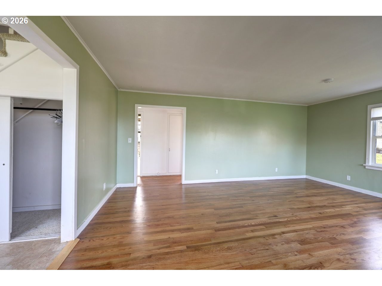 135 Southwest 2nd Street Warrenton, OR 97146 - Photo 23 of 46 a view of an empty room with wooden floor and a window
