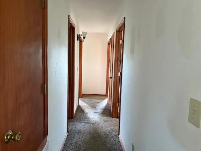 a view of hallway with a door and a window