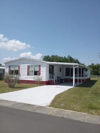 a view of a house with a patio and a yard