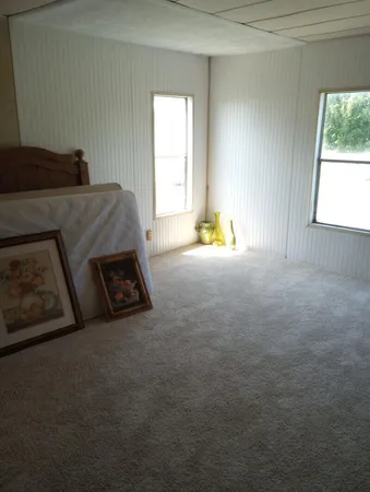a bed sitting in a spacious bedroom next to a window