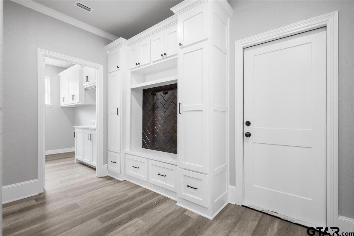 19462 Cedarpark Place Lindale, TX 75771 - Photo 21 of 48 a view of a hallway with wooden floor and cabinet