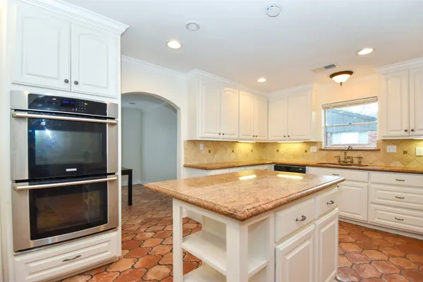 a kitchen with granite countertop a stove microwave and sink