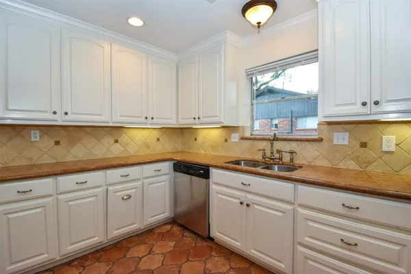 a kitchen with granite countertop white cabinets and stainless steel appliances