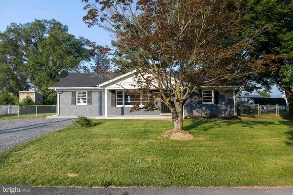 a view of a house with a big yard and large trees