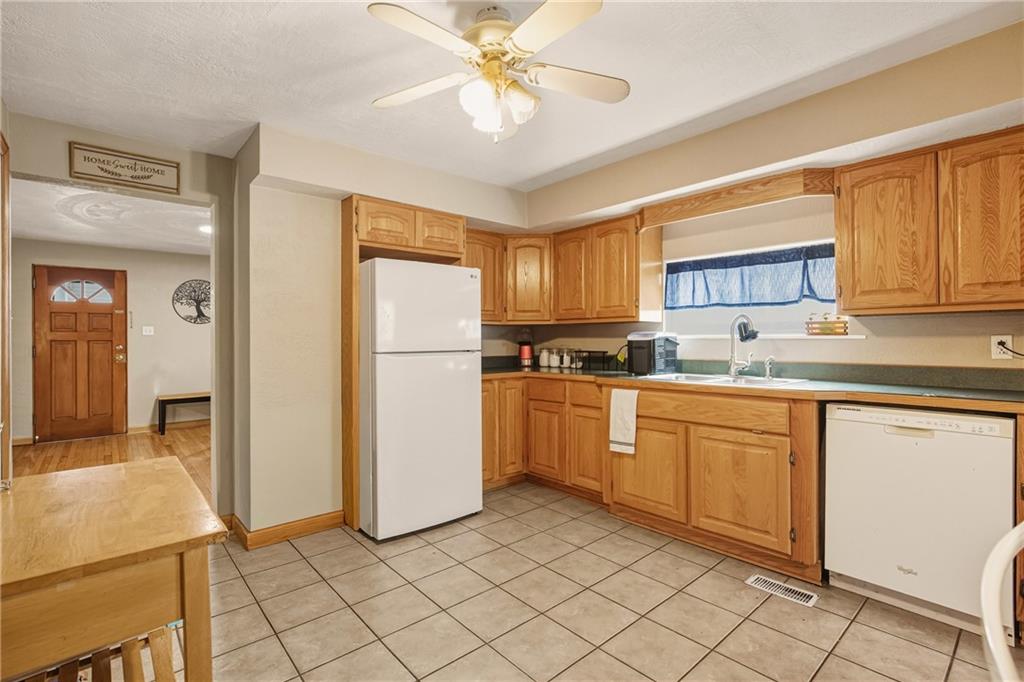 36 3rd Street Cairnbrook, PA 15924 - Photo 12 of 50 a kitchen with a refrigerator a stove a sink cabinets and a dining table