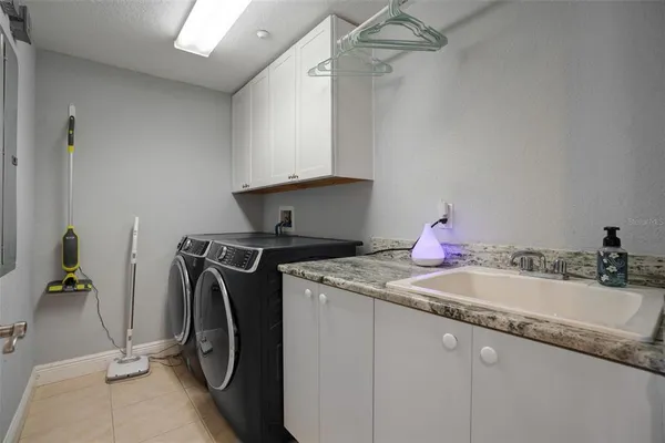 a utility room with sink dryer and washer