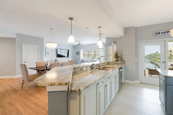 a kitchen with kitchen island granite countertop a stove a sink a table and chairs