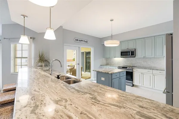 a large kitchen with granite countertop a stove oven and a sink with granite countertops