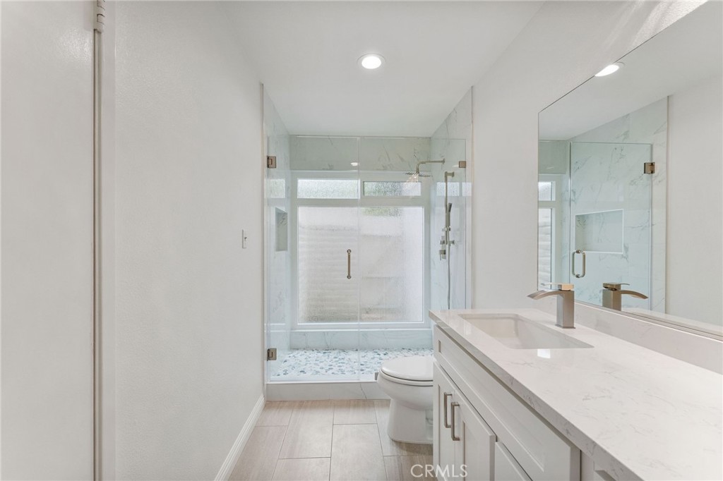 46 Cedar Tree Lane Irvine, CA 92612 - Photo 15 of 44 a bathroom with a granite countertop sink a toilet a mirror and shower