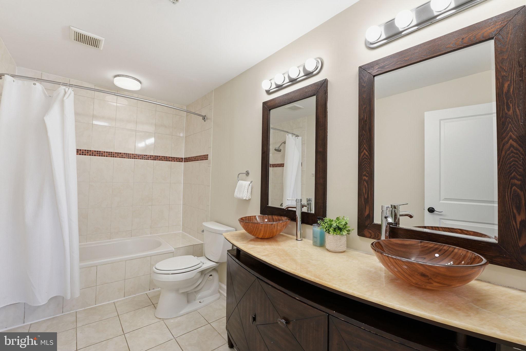 1917 2nd Street Northeast, Unit 301 Washington, DC 20002 - Photo 14 of 20 a bathroom with a granite countertop sink a toilet a mirror and shower