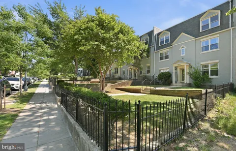 a view of a brick house with large trees