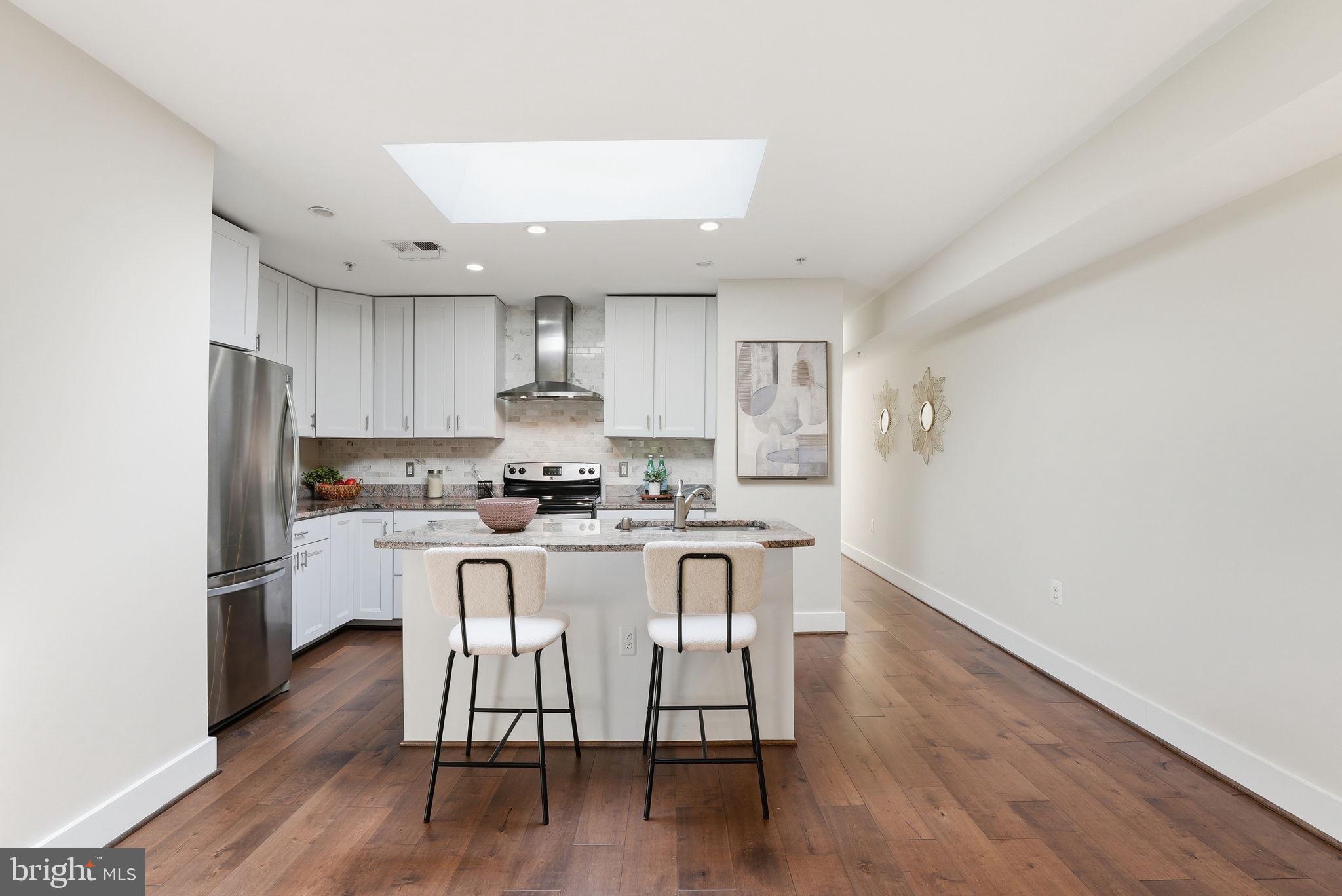 1917 2nd Street Northeast, Unit 301 Washington, DC 20002 - Photo 5 of 20 a kitchen with wooden floors and white stainless steel appliances