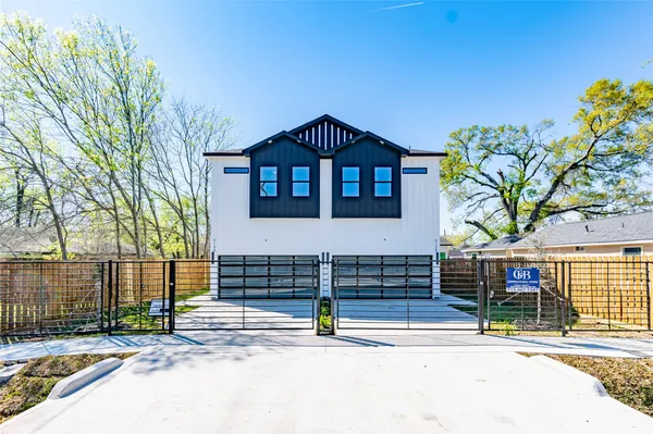 a view of a brick house with large windows and a table and chairs