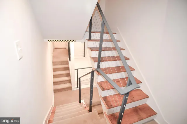 an empty room with wooden floor and a kitchen