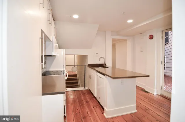 a view of hallway with furniture and wooden floor