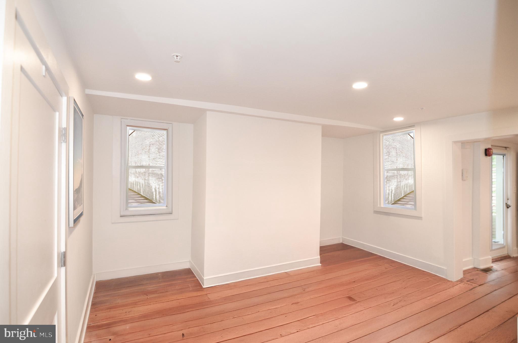 1072 Thomas Jefferson Street Northwest Washington, DC 20007 - Photo 9 of 58 an empty room with wooden floor and windows