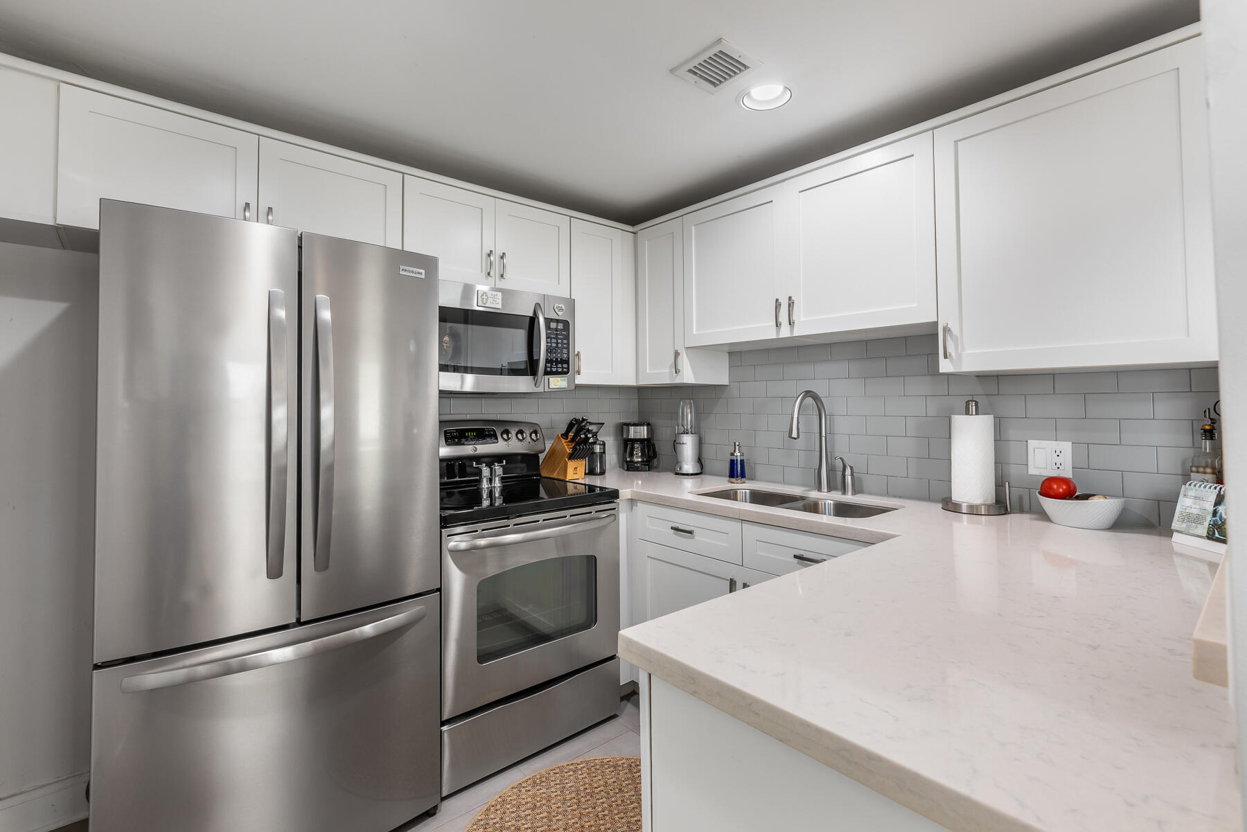 404 Porter Lane, Unit 16 Key West, FL 33040 - Photo 13 of 22 a kitchen with stainless steel appliances granite countertop a refrigerator stove a sink dishwasher and white cabinets