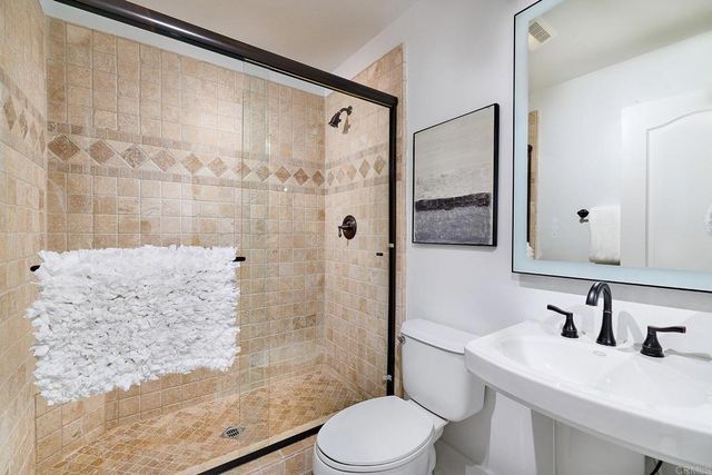 a bathroom with a sink a toilet and shower