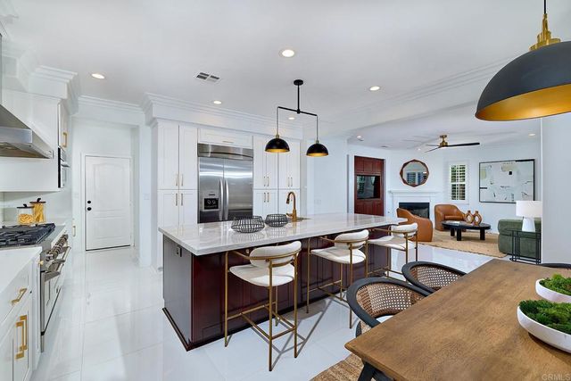 a living room with fireplace furniture and a view of kitchen