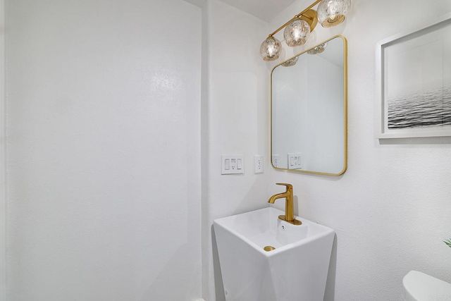 a bathroom with a sink and mirror with toilet