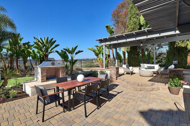a view of a patio with table and chairs potted plants and palm trees