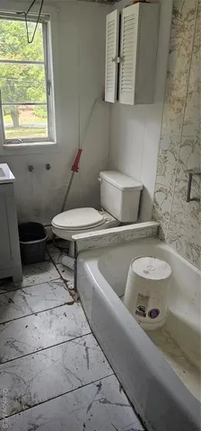 a bathroom with a toilet sink and mirror