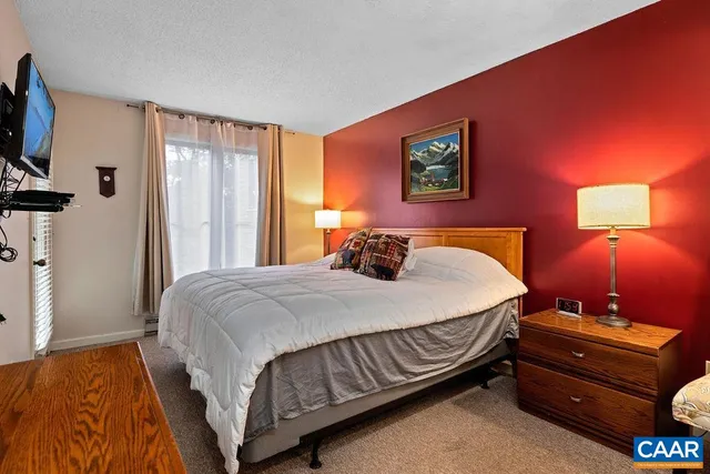 a bedroom with a bed and dresser with mirror