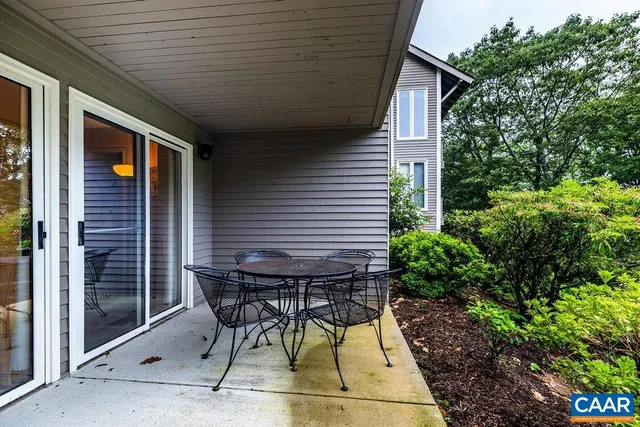 a patio with table and chairs and potted plants