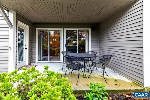 a view of a patio with table and chairs and potted plants with wooden floor