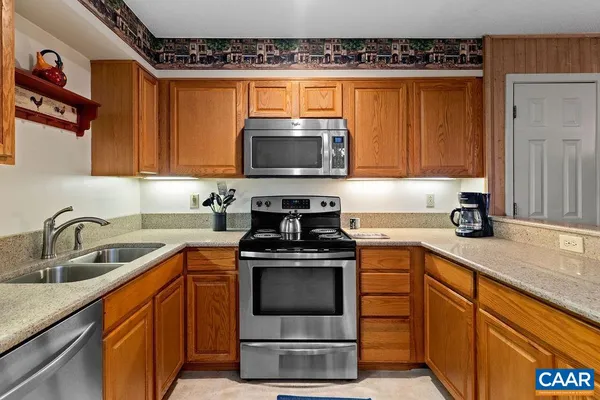 a kitchen with stainless steel appliances granite countertop a sink stove and microwave