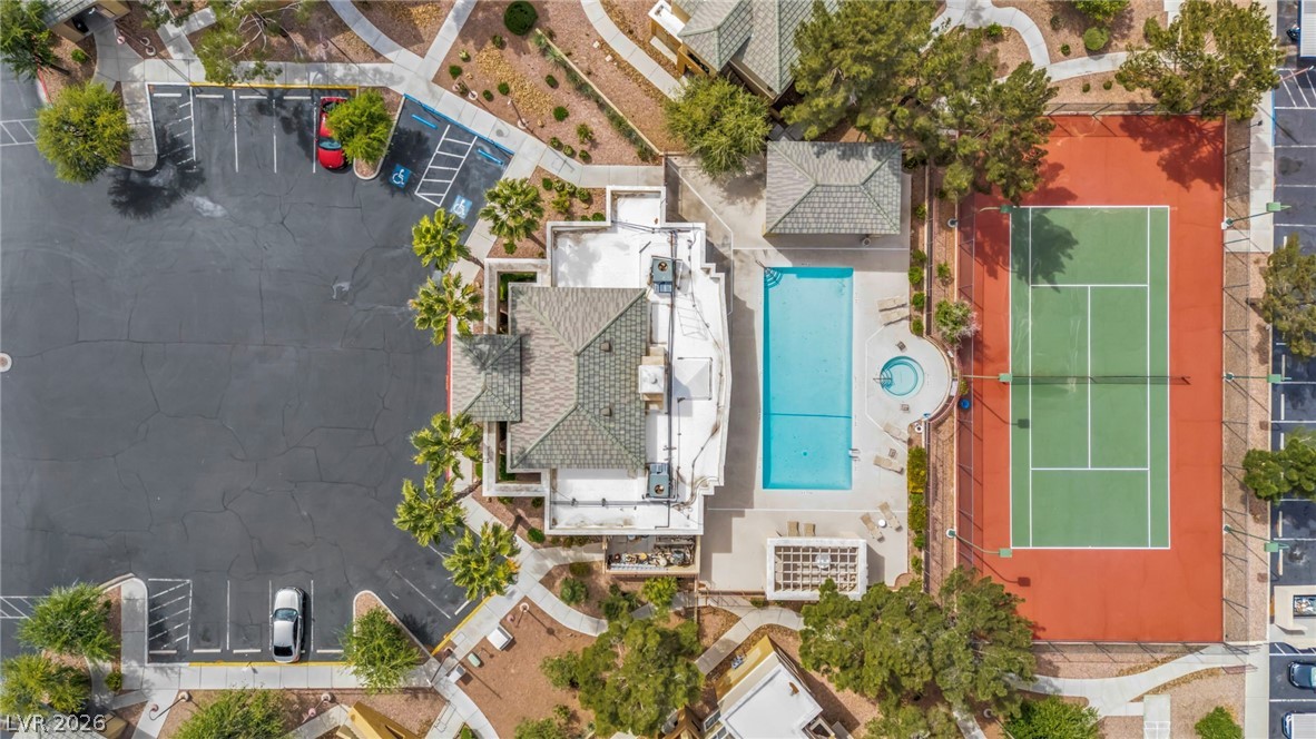 8070 West Russell Road, Unit 2060 Las Vegas, NV 89113 - Photo 44 of 47 An aerial view showcases an inviting pool, tennis court, and ample parking, offering recreational enjoyment.