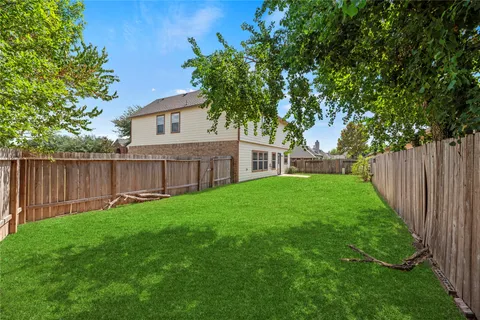 a view of a house with backyard and a tree