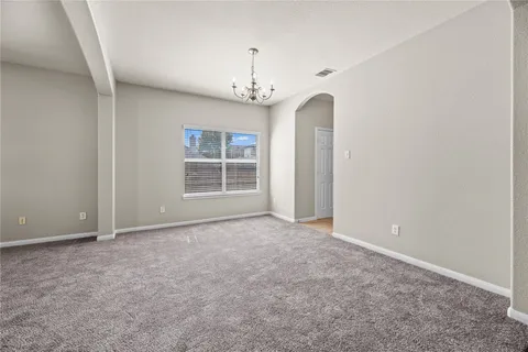 an empty room with windows and chandelier