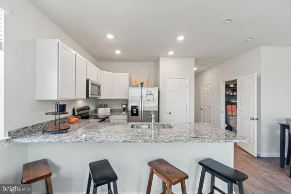 a kitchen with stainless steel appliances granite countertop a refrigerator and a sink