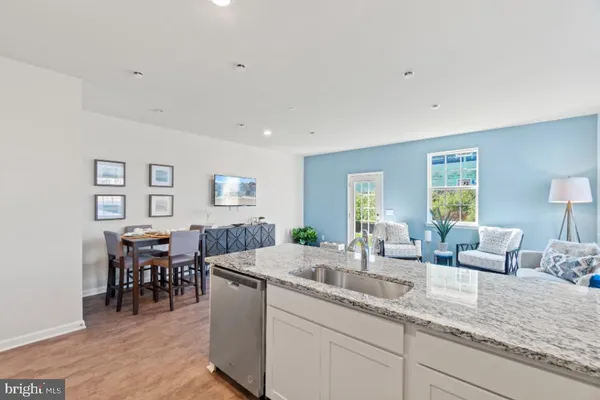 a kitchen with stainless steel appliances granite countertop dining table chairs sink and cabinets
