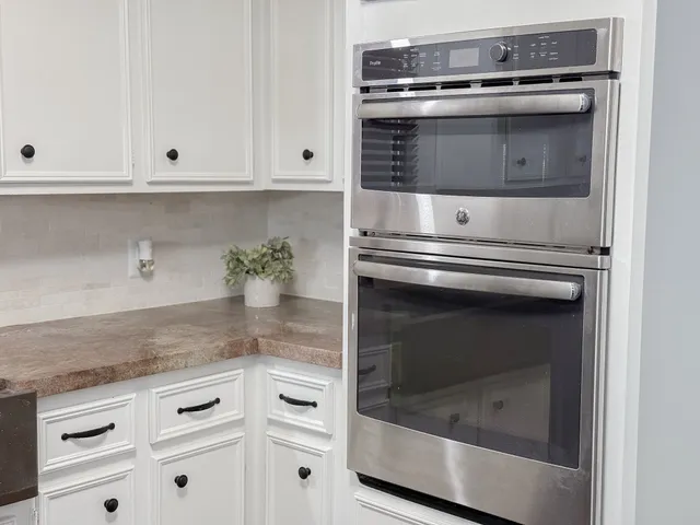 a stove top oven sitting inside of a kitchen