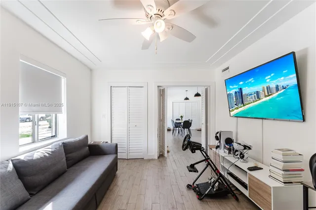 a living room with furniture a flat screen tv and a window