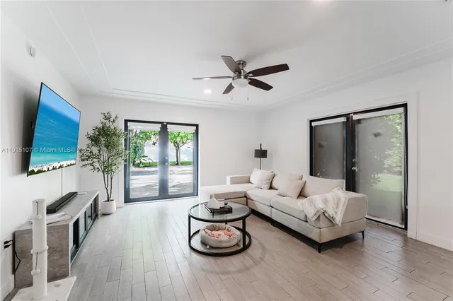 a living room with furniture a flat screen tv and a large window