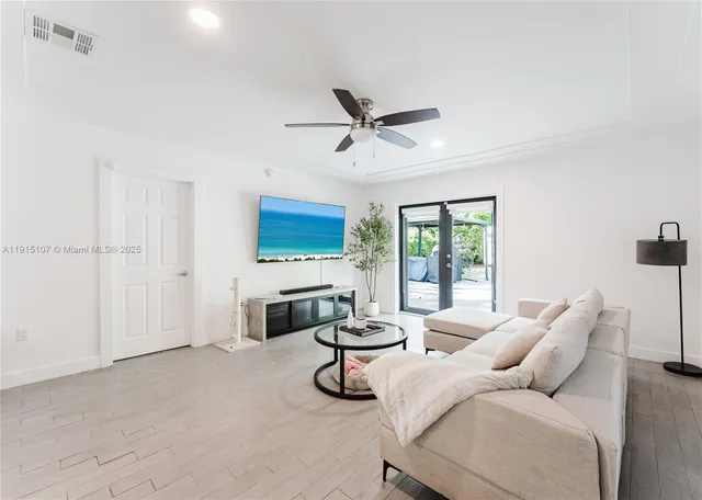 a living room with furniture white walls and a flat screen tv