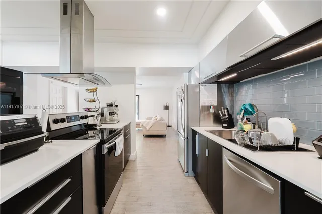a kitchen with stainless steel appliances a sink stove and refrigerator