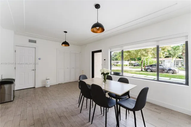 a dining room with furniture a chandelier and wooden floor