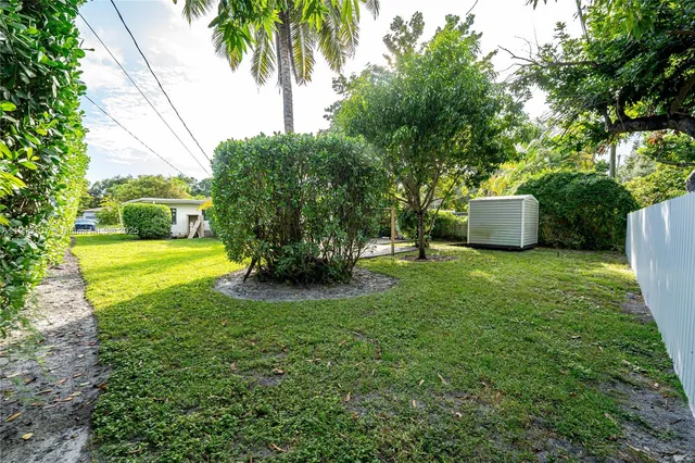 a view of a backyard with plants and a barbeque